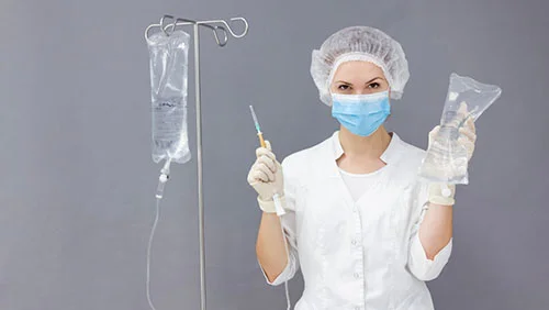 врач с капельницей на сером фоне